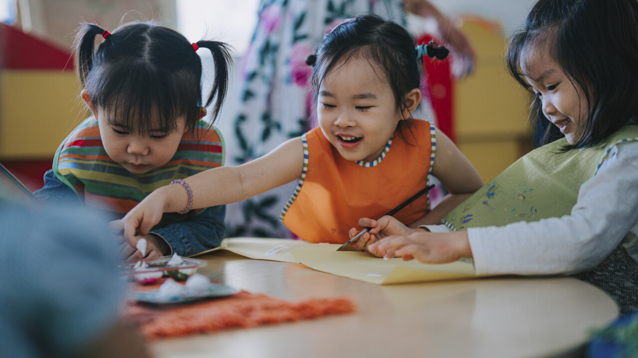 A group of young children playing at a table.